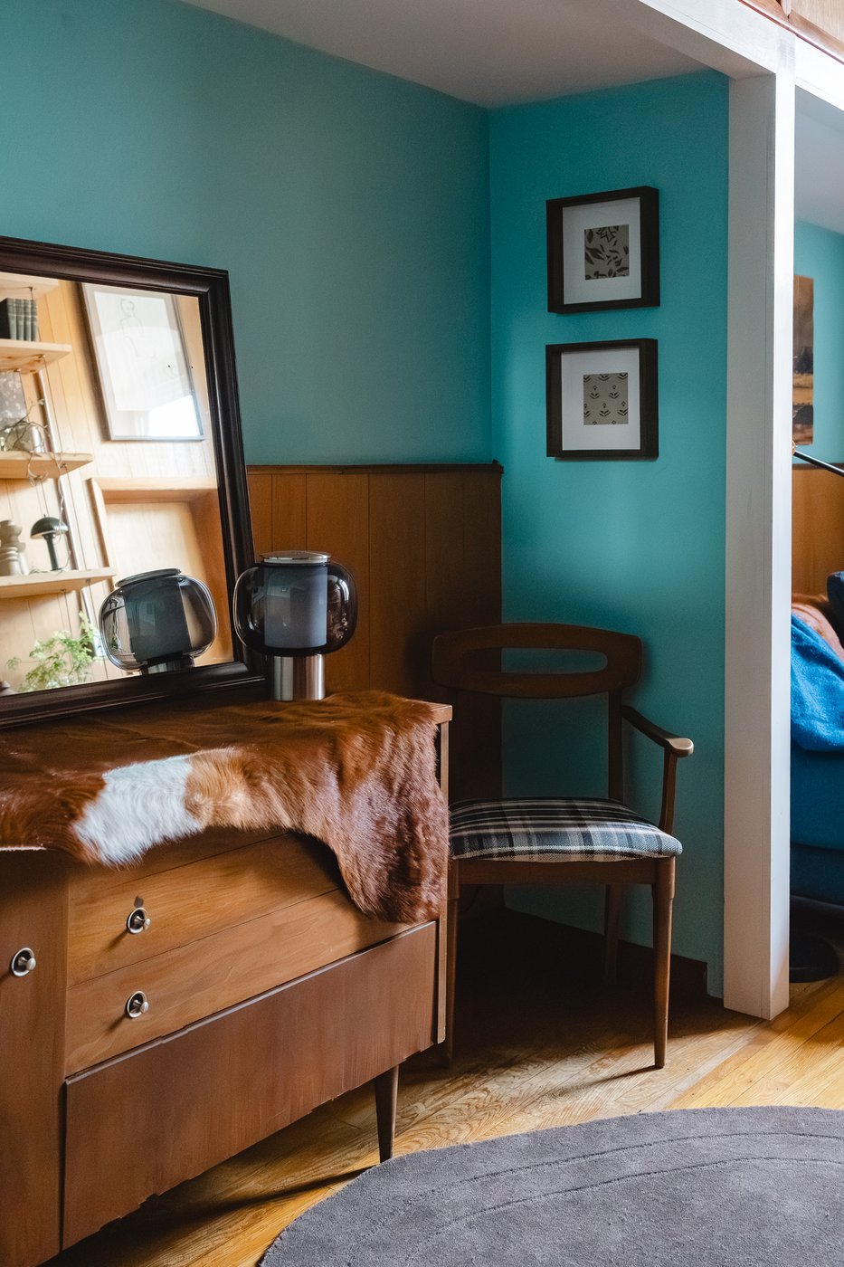 Detail of the East Falls office — vintage wooden dresser with a framed mirror and small artwork on a teal wall